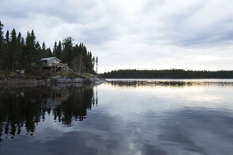 Ce chalet est situé en bordure de lac, offrant une vue paisible sur la forêt environnante.