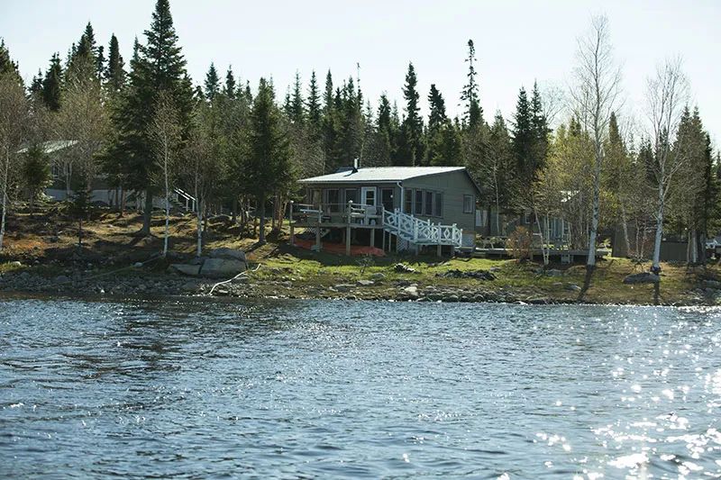 Vue depuis l'eau sur les chalets de la pourvoirie situés en bordure du lac.