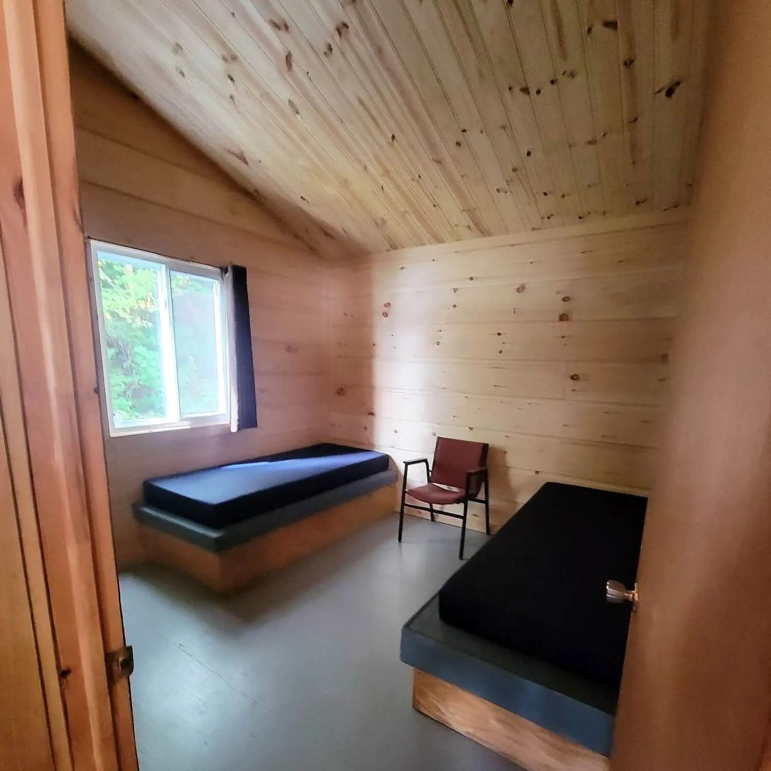Cette chambre du chalet dispose de deux lits simples et d'une chaise pour votre confort.
