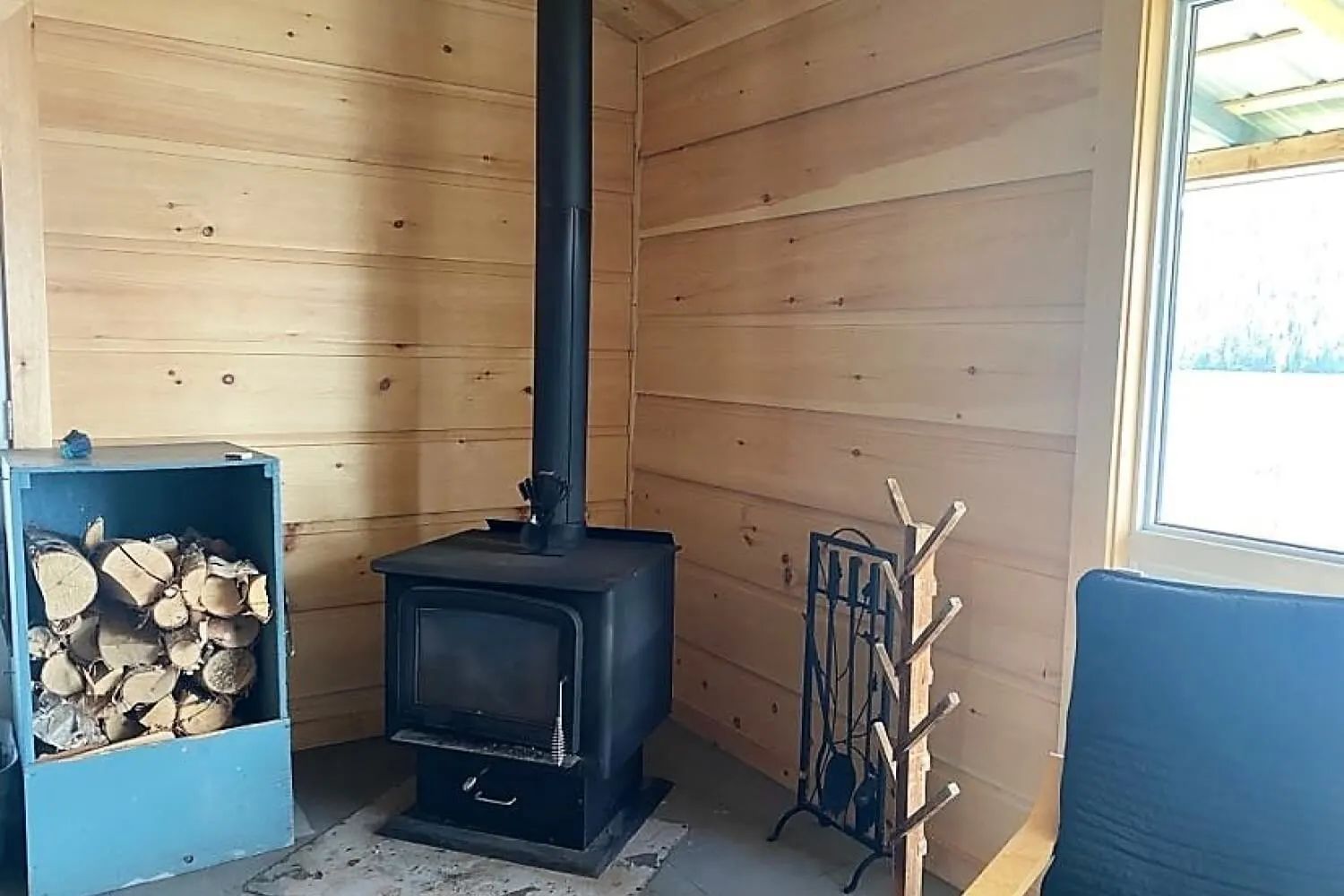 Le poêle à bois dans le coin du chalet offre une source de chaleur réconfortante.