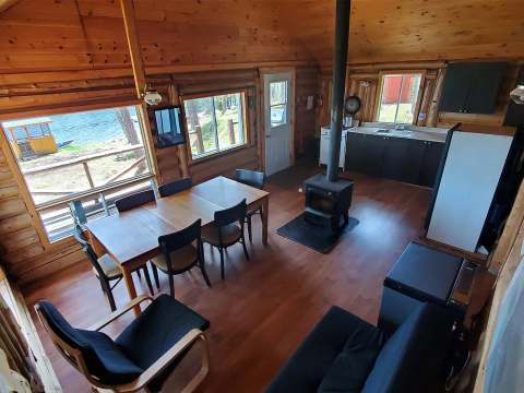 The open area of the cabin includes a fully equipped kitchen, a dining table, and a cozy seating area.
