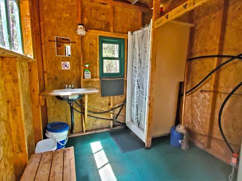 View of the functional bathroom with shower and sink inside the cabin.