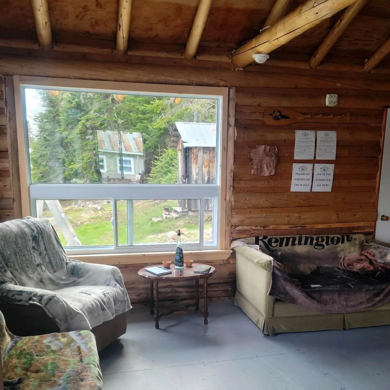 Coin salon accueillant avec vue sur les bâtiments extérieurs depuis le chalet.