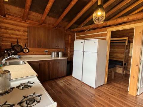 La cuisine équipée du chalet dispose d'une cuisinière, de réfrigérateurs et d'un coin repas attenant.