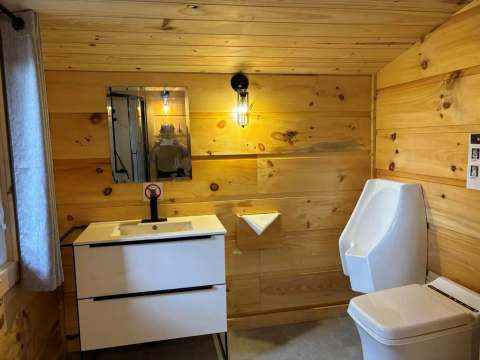 Vue de la salle de bain du chalet, équipée d'une vanité moderne et de sanitaires fonctionnels.