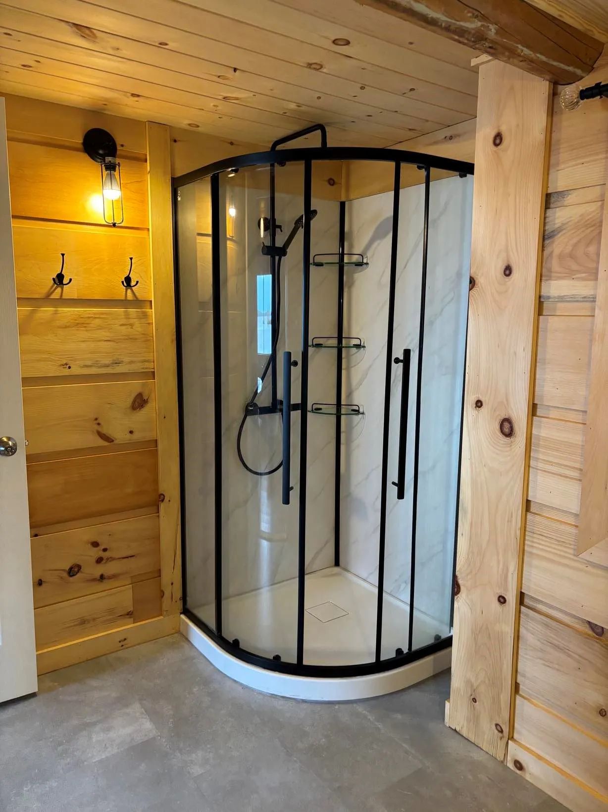 La salle de bain du chalet comprend une douche en coin moderne avec portes vitrées.