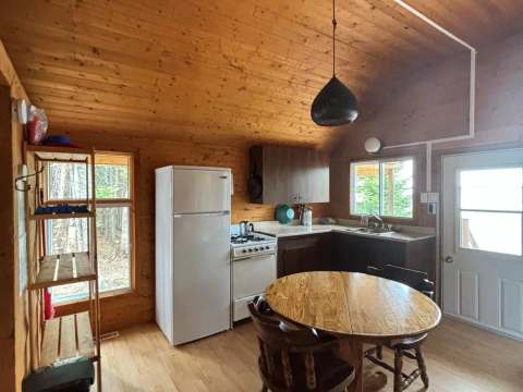La cuisine fonctionnelle du chalet comprend une table à manger et les équipements de base.