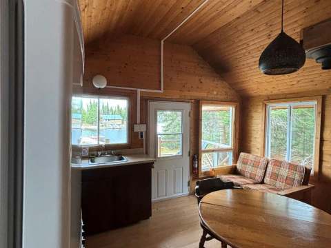 Vue de l'aire de vie principale du chalet, incluant la cuisine, le coin repas et le salon.