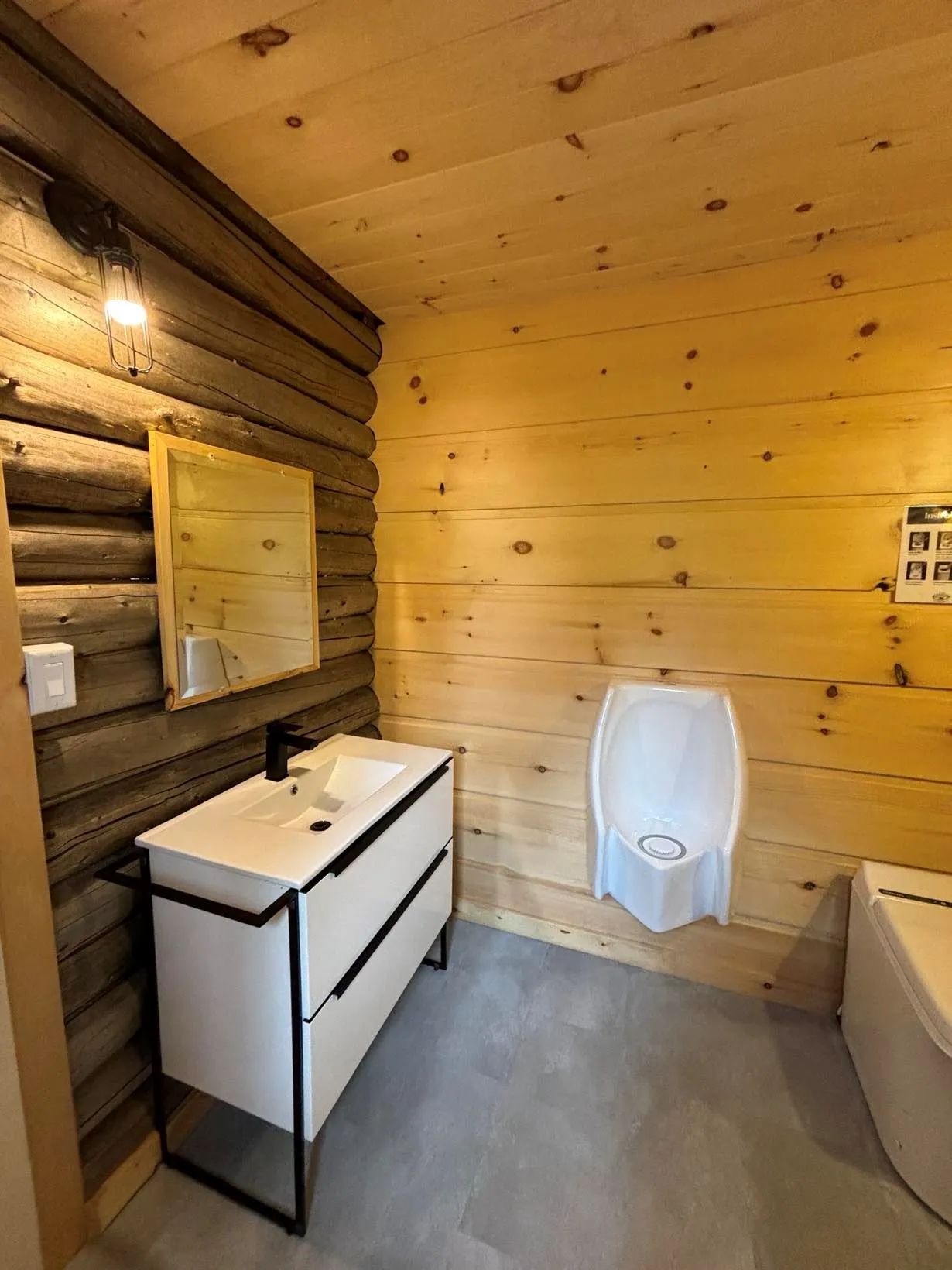 La salle de bain du chalet dispose d'une vanité moderne et d'un urinoir.