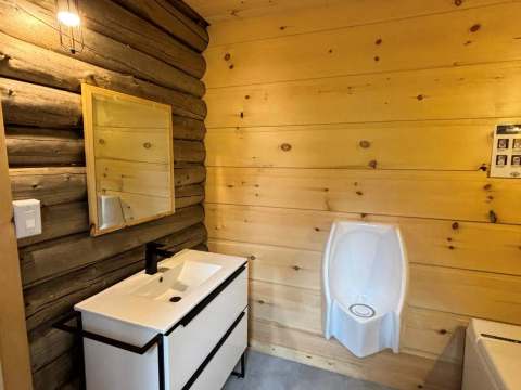 La salle de bain du chalet dispose d'une vanité moderne et d'un urinoir.
