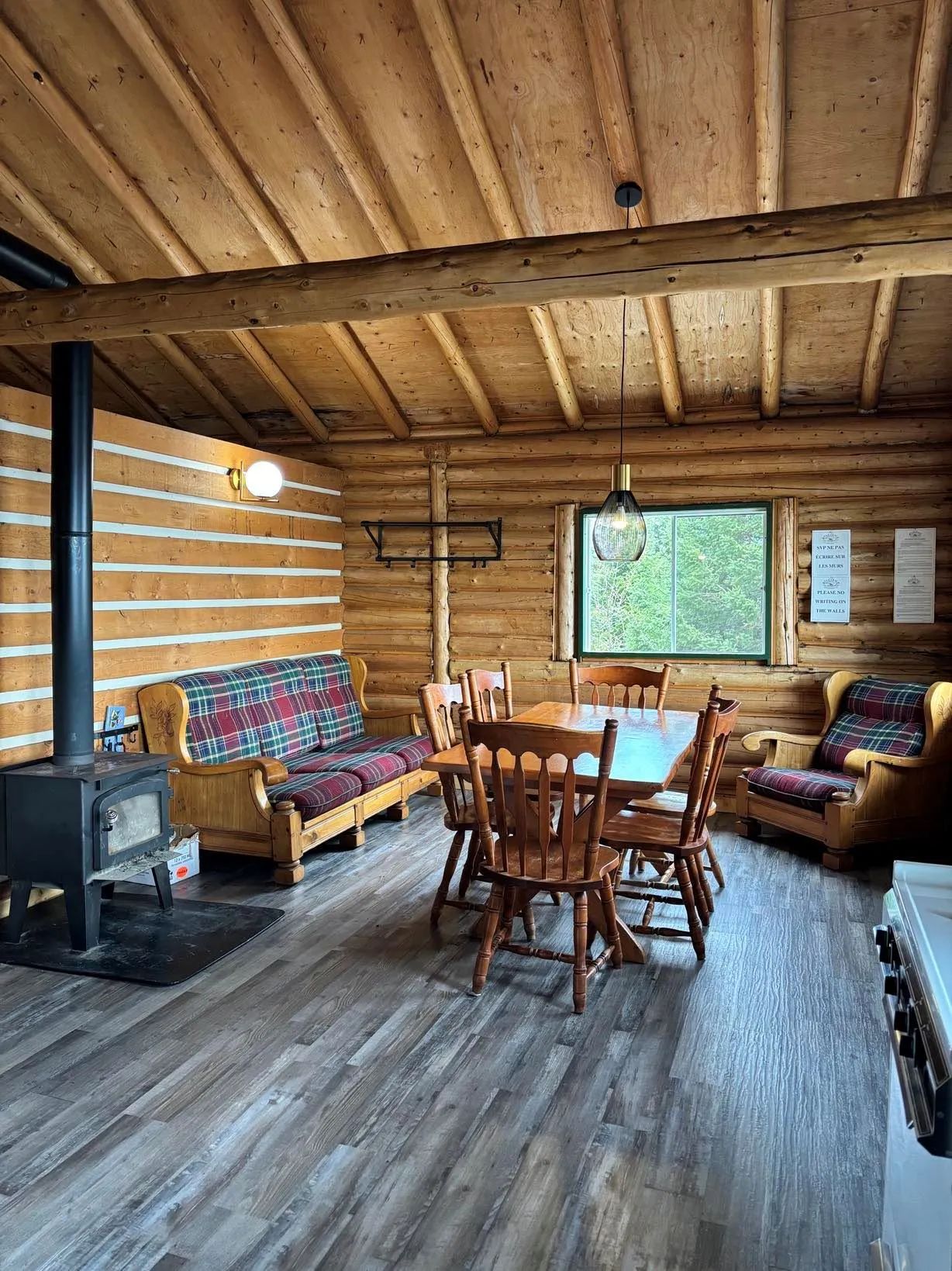 La salle à manger du chalet dispose d'un poêle à bois et d'un coin salon confortable.