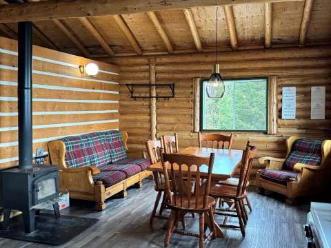 La salle à manger du chalet dispose d'un poêle à bois et d'un coin salon confortable.