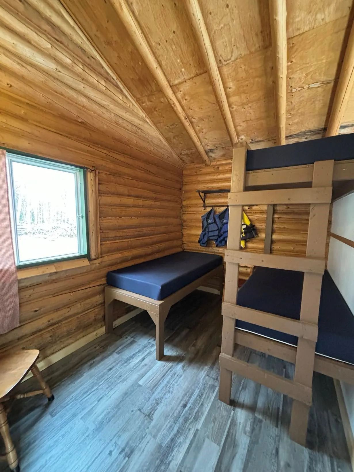 Vue intérieure de la chambre du chalet numéro vingt-trois avec ses lits simples et superposés.