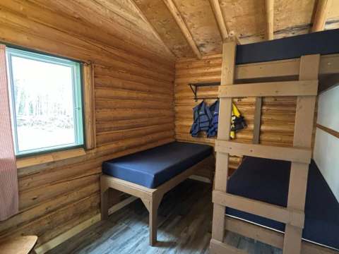 Vue intérieure de la chambre du chalet numéro vingt-trois avec ses lits simples et superposés.
