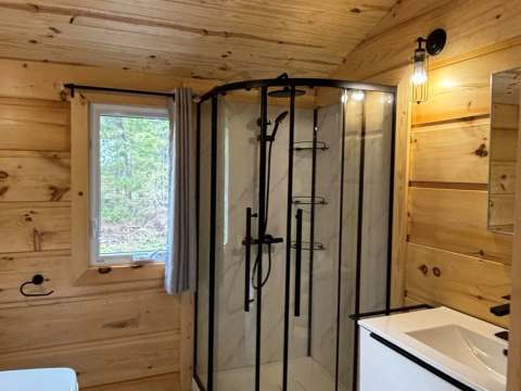 Vue de la salle de bain moderne avec douche vitrée située dans le chalet.
