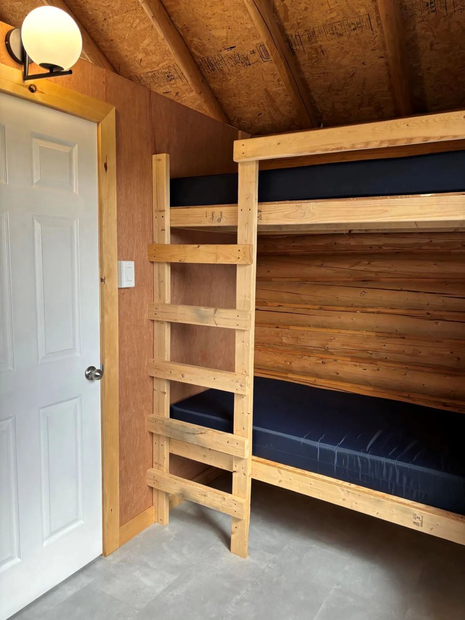 Un lit superposé en bois est installé dans l'une des chambres du chalet.