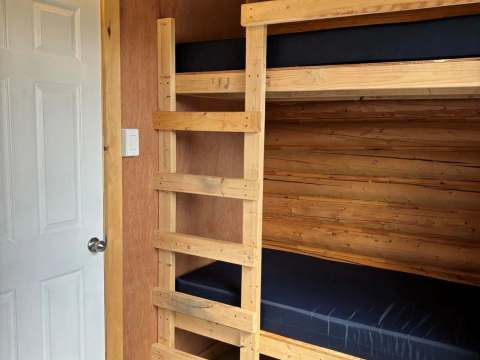 Un lit superposé en bois est installé dans l'une des chambres du chalet.