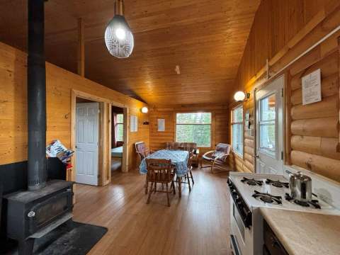 Vue sur l'aire ouverte et la cuisine du chalet 26 avec son poêle à bois.