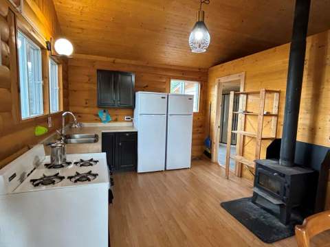 La cuisine du chalet #26 est équipée d'une cuisinière, de réfrigérateurs et d'un poêle à bois.