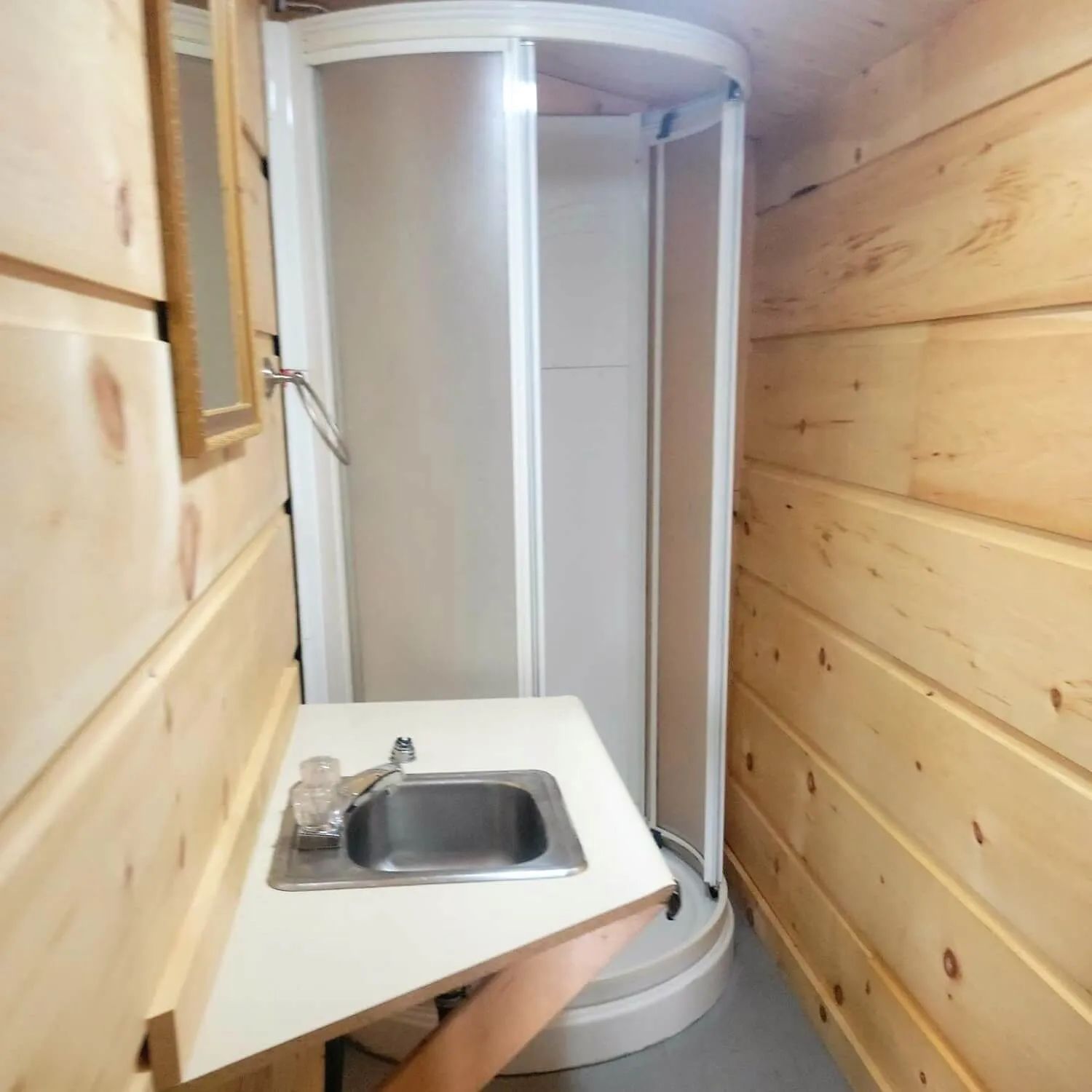 La salle de bain du chalet comprend une douche et un lavabo intégré.