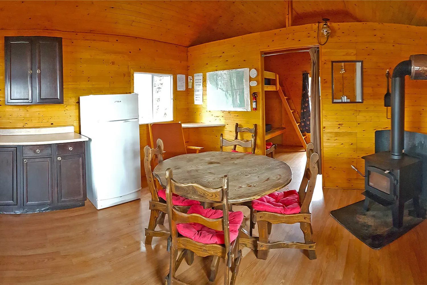 Vue d'ensemble de la cuisine et de la salle à manger du chalet 31 avec son poêle à bois.