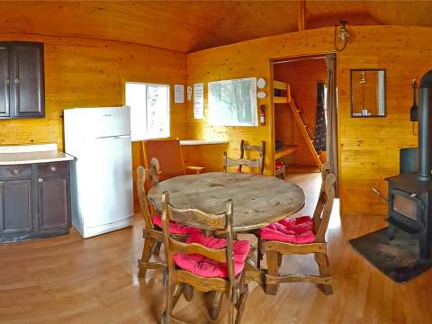 Vue d'ensemble de la cuisine et de la salle à manger du chalet 31 avec son poêle à bois.