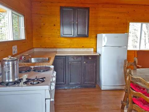 La cuisine équipée du chalet dispose d'une cuisinière au gaz, d'un réfrigérateur et d'un coin repas.