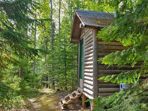 Le chalet en bois rond est situé en plein cœur de la forêt.