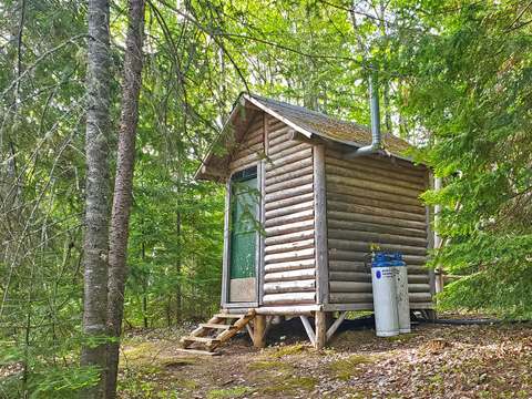 Vue extérieure du petit bâtiment rustique en bois situé en forêt.