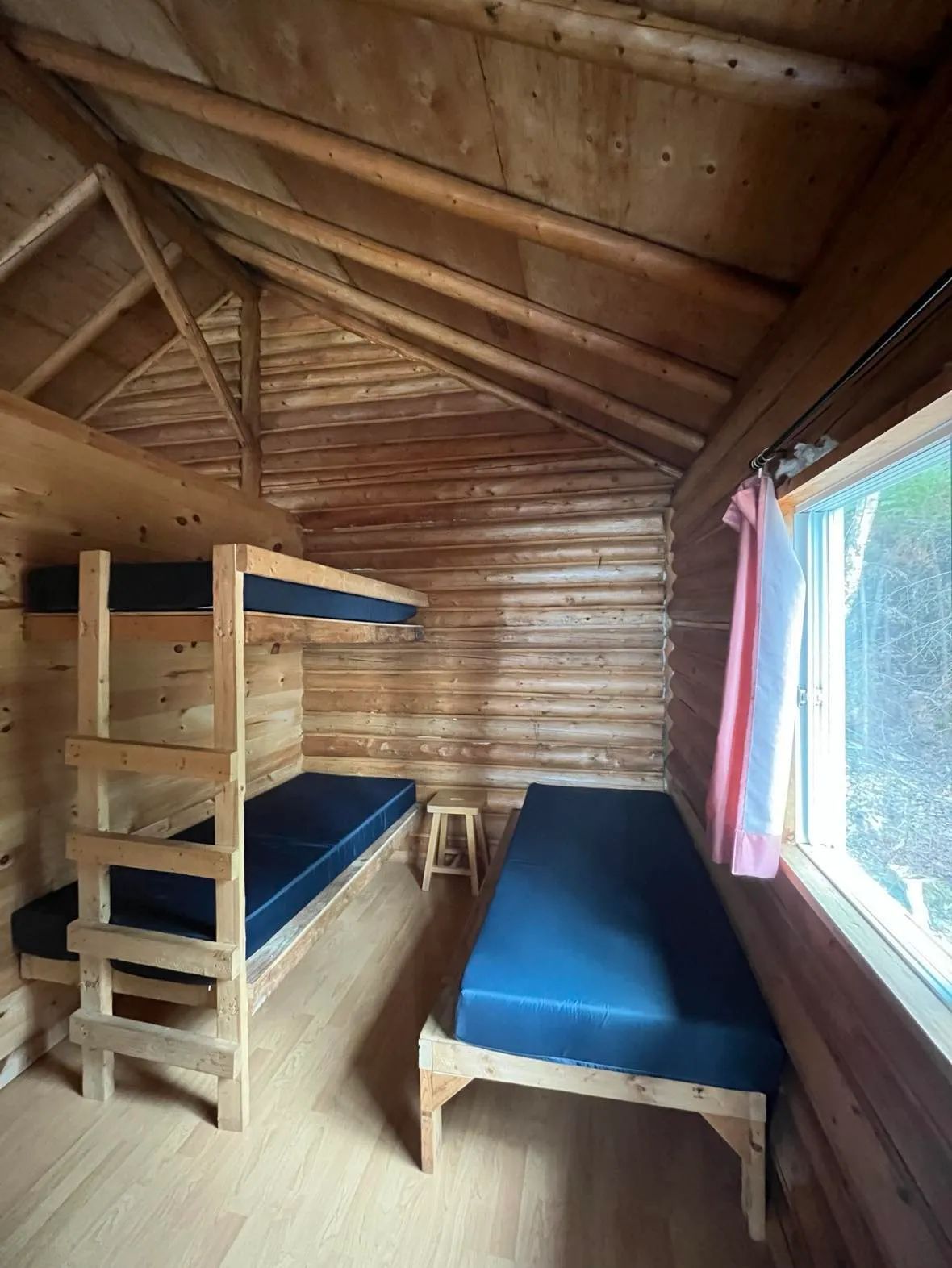 Cette chambre rustique du chalet comprend des lits superposés et un lit simple.