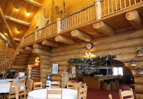 The lodge's common area and bar feature warm log construction architecture.
