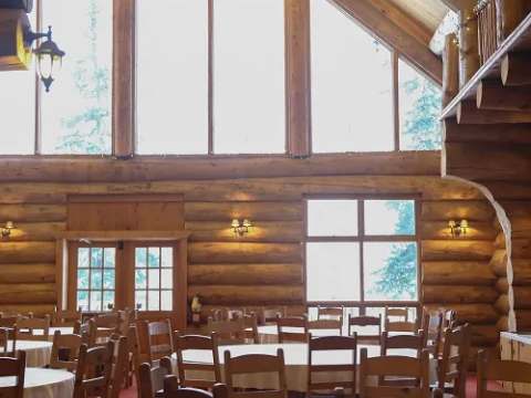 The main dining room offers a vast, warm space with its log walls.