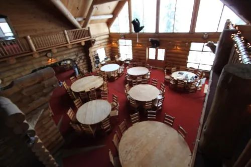The inn's dining room featuring wooden tables and a log structure.