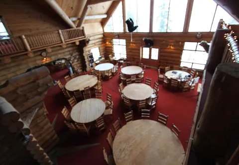 The inn's dining room featuring wooden tables and a log structure.