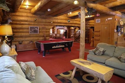 The lodge's common area includes a lounge space and a pool table.