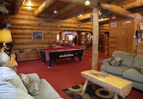 The lodge's common area includes a lounge space and a pool table.