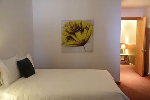 This cozy inn bedroom is decorated with a floral canvas.