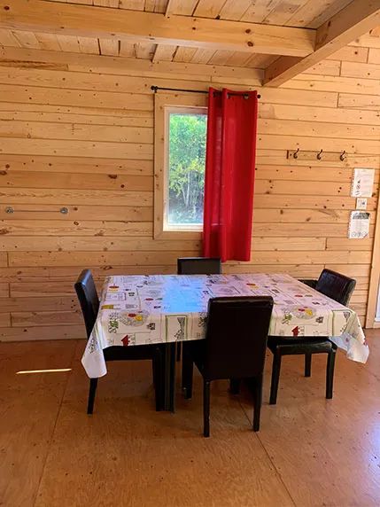 La salle à manger du chalet dispose d'une table et de chaises en bois.