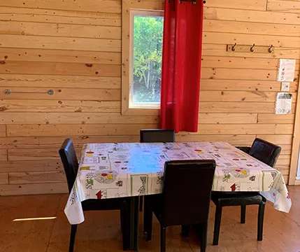 La salle à manger du chalet dispose d'une table et de chaises en bois.