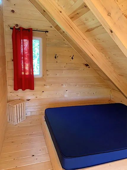 Coin chambre mansardé avec lit simple dans le chalet.