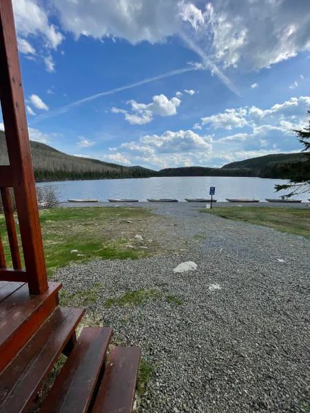 Vue sur le lac et le rivage depuis la galerie du chalet.