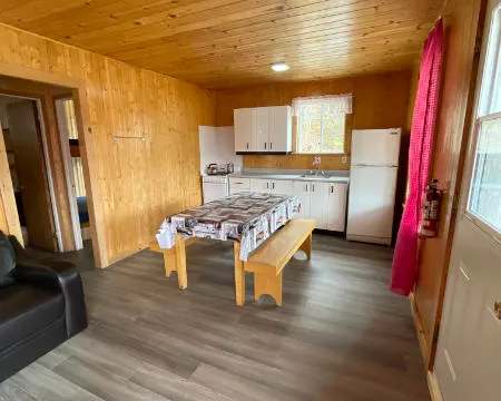 La cuisine fonctionnelle du chalet comprend une table à manger et des équipements essentiels.