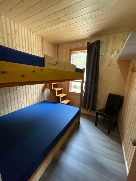 Cette chambre du chalet 5 comprend un lit superposé avec des matelas bleus.