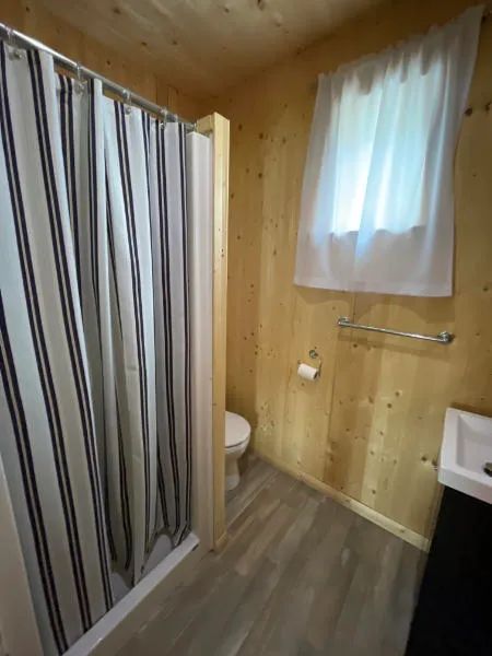 La salle de bain du chalet comprend une douche, une toilette et un lavabo.