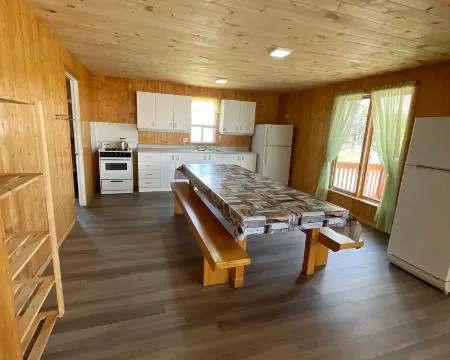 La cuisine fonctionnelle du chalet comprend une grande table en bois et tout l'équipement nécessaire.