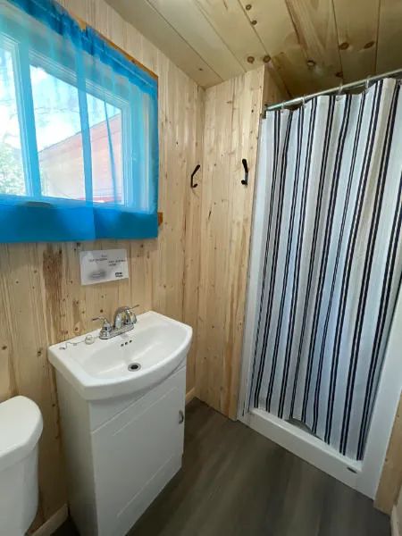 Vue de la salle de bain fonctionnelle avec douche et lavabo dans le chalet 7.
