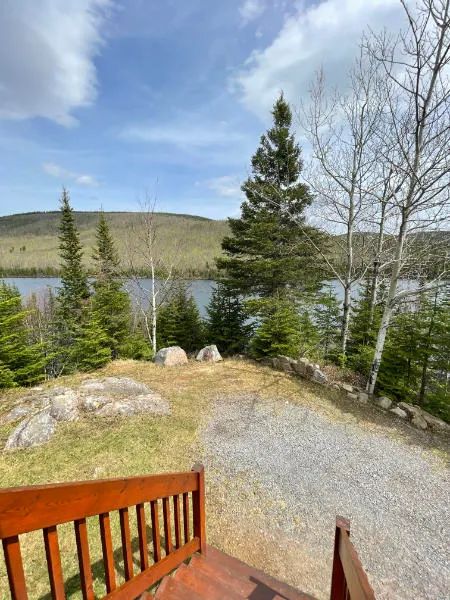 Vue sur le lac et la forêt depuis la galerie du chalet 8.