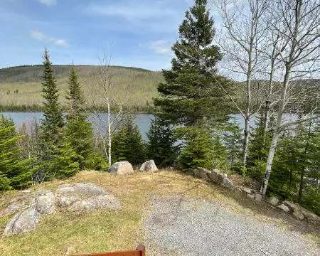 Vue sur le lac et la forêt depuis la galerie du chalet 8.