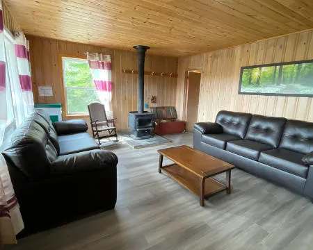 Le salon du chalet 9 offre un espace de détente confortable avec son poêle à bois.