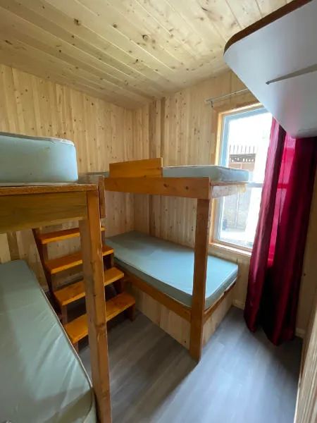 Cette chambre du chalet comprend des lits superposés en bois avec matelas.